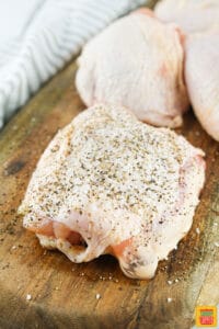 Seasoned chicken thigh on a cutting board