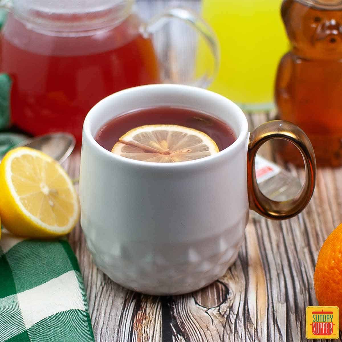 starbucks medicine ball tea in a mug with a slice of lemon next to honey