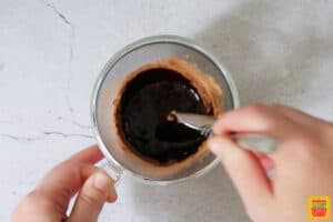 mixing oil and cocoa powder together for mug brownie