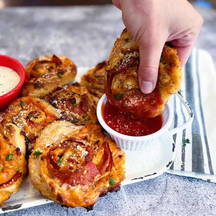 dipping a pizza roll in marinara sauce