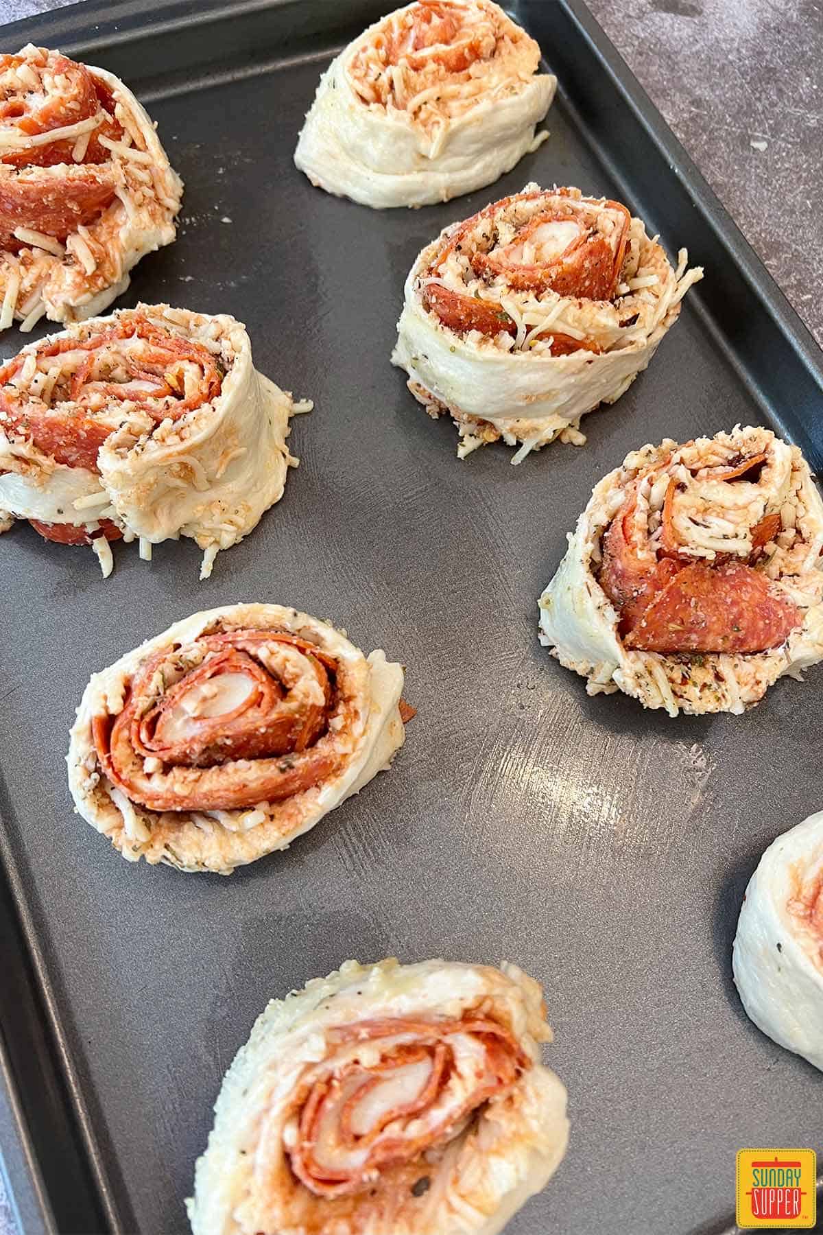 pizza rolls uncooked on a baking sheet