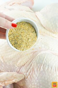adding seasoning to turkey