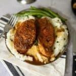 instant pot pork chops over mashed potatoes and green beans in the back