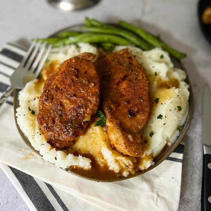 instant pot pork chops over mashed potatoes and green beans in the back