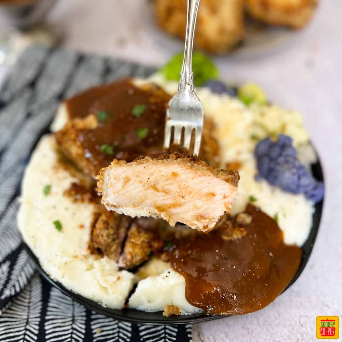 oven baked pork chops over mashed potatoes with pork gravy