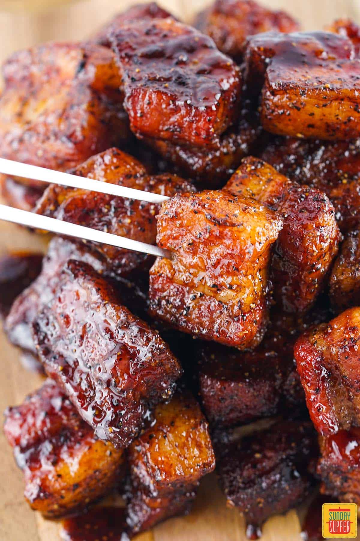 cubed smoked pork belly burnt ends with a meat fork