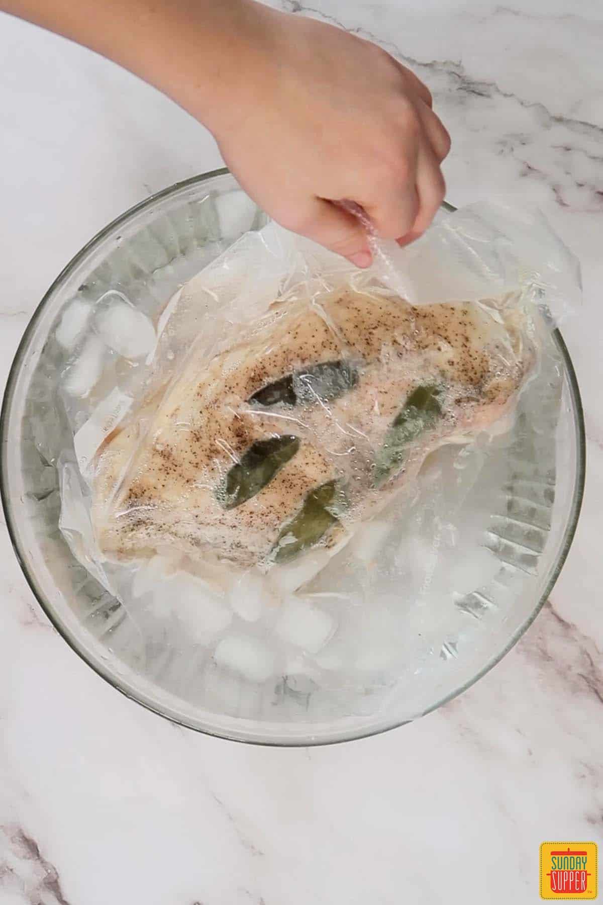 adding sous vide turkey bag to an ice bath