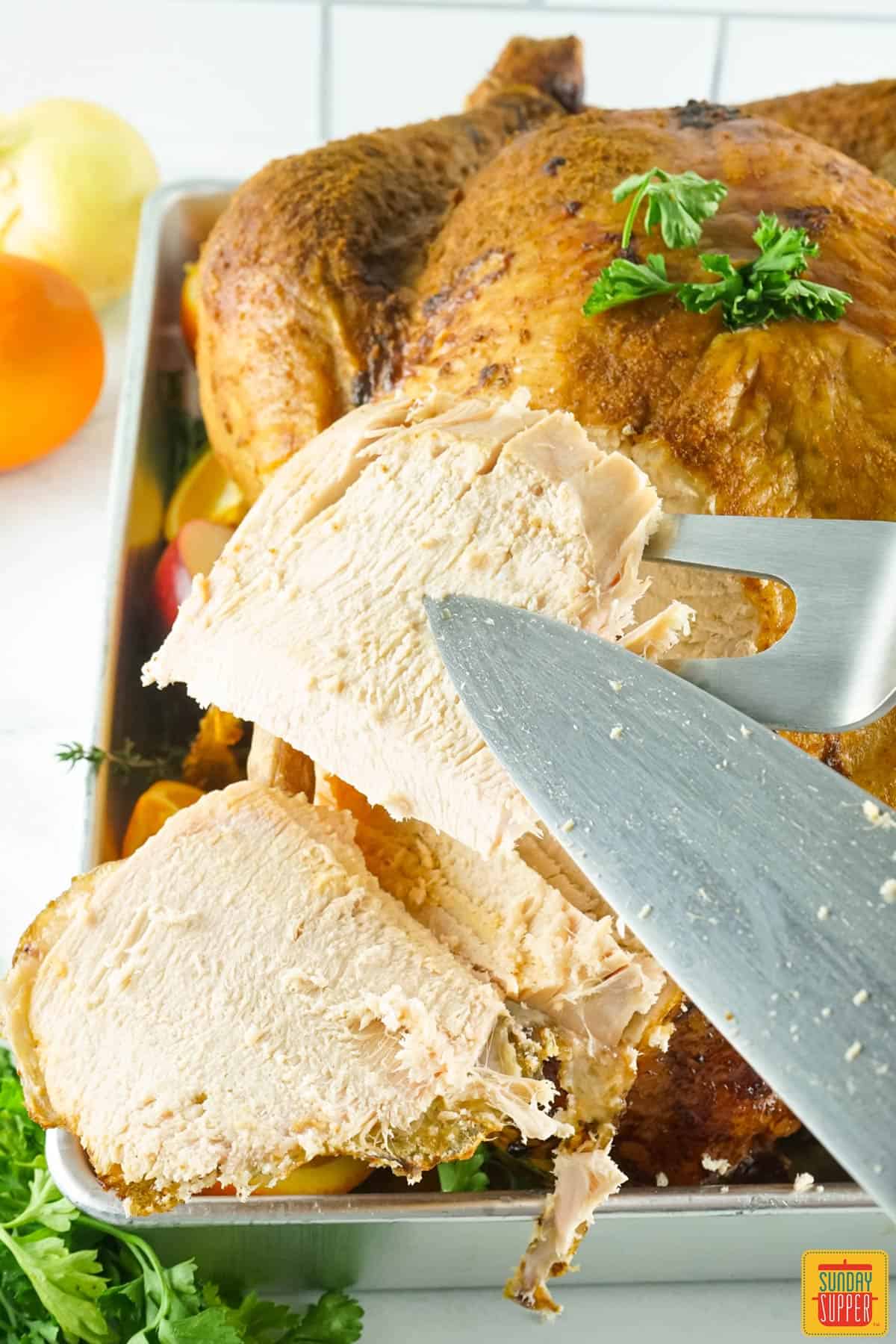 slicing smoked turkey with a knife and fork