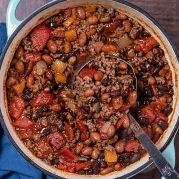 blue pot of beef chili with a ladle