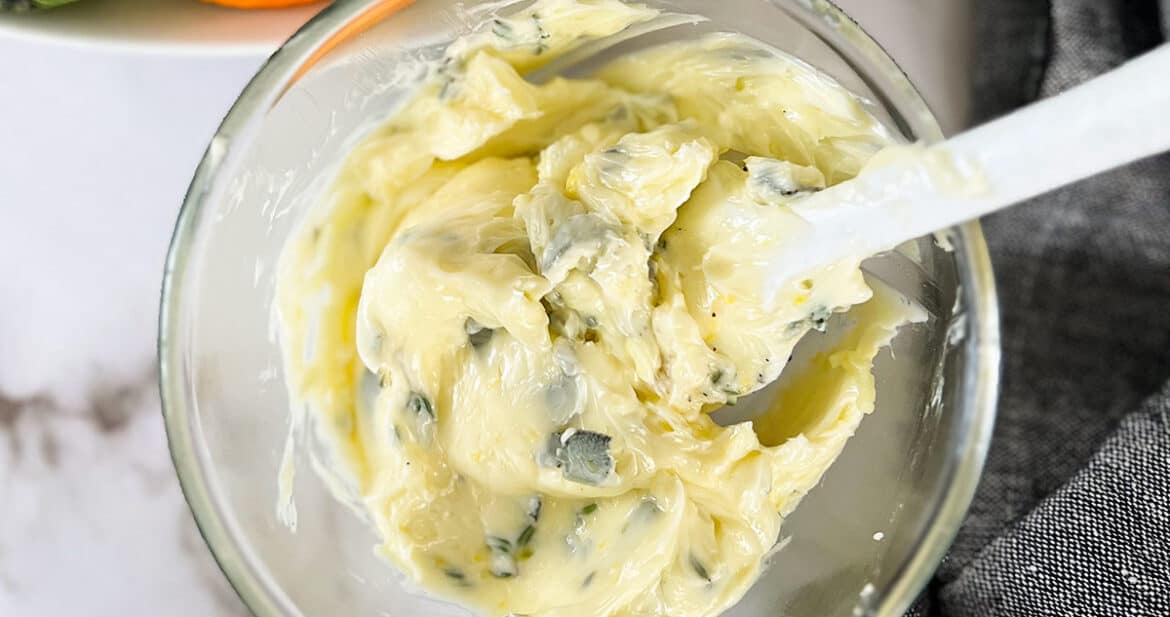 compound butter for turkey in a clear dish with a white spoon next to a turkey
