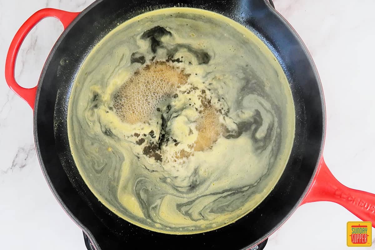 water, orange juice and brown sugar boiling in a saucepan