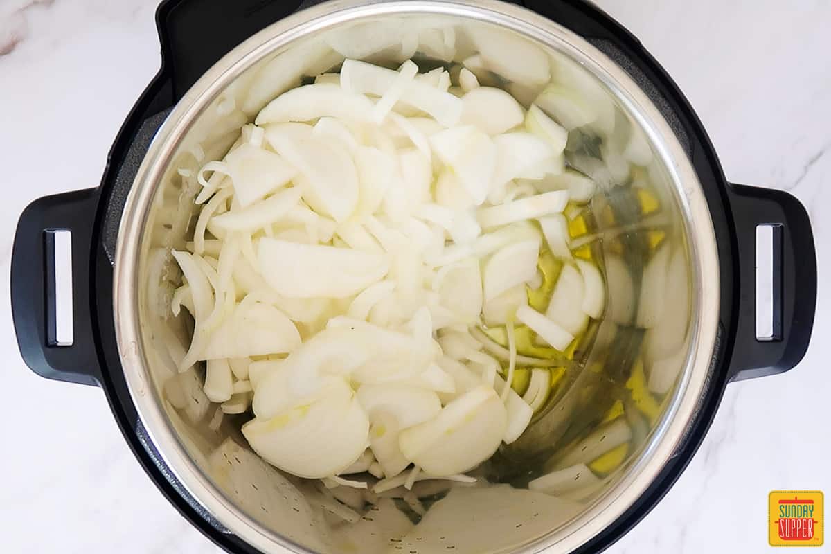 olive oil and sliced onions inside of the instant pot