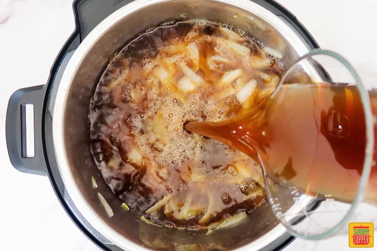 pouring beef broth into the instant pot