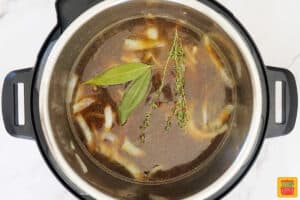 adding herbs inside of the instant pot for French onion soup
