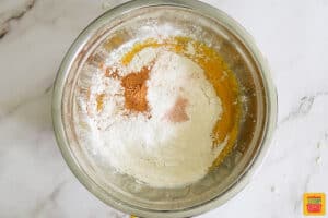flour, baking powder, salt, and pumpkin pie spice in bowl with pumpkin puree