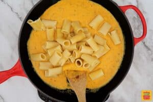 adding pasta to butternut squash cheese sauce