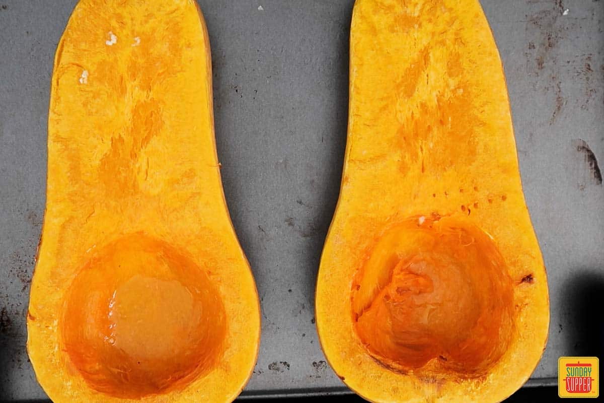 two butternut squashes on a baking sheet after roasting