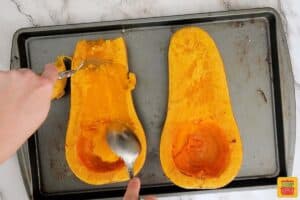 scooping out butternut squash after roasting
