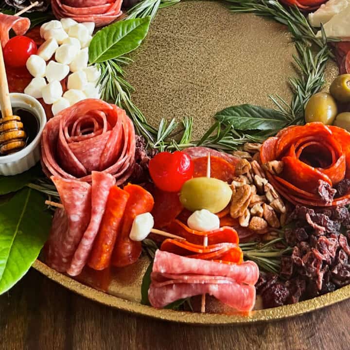 holiday charcuterie board with salami, pepperoni, olives, cheeses, and more, in the shape of a wreath