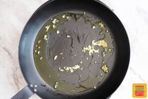 olive oil and minced garlic in a black skillet