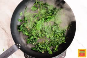 wilted spinach in a black skillet