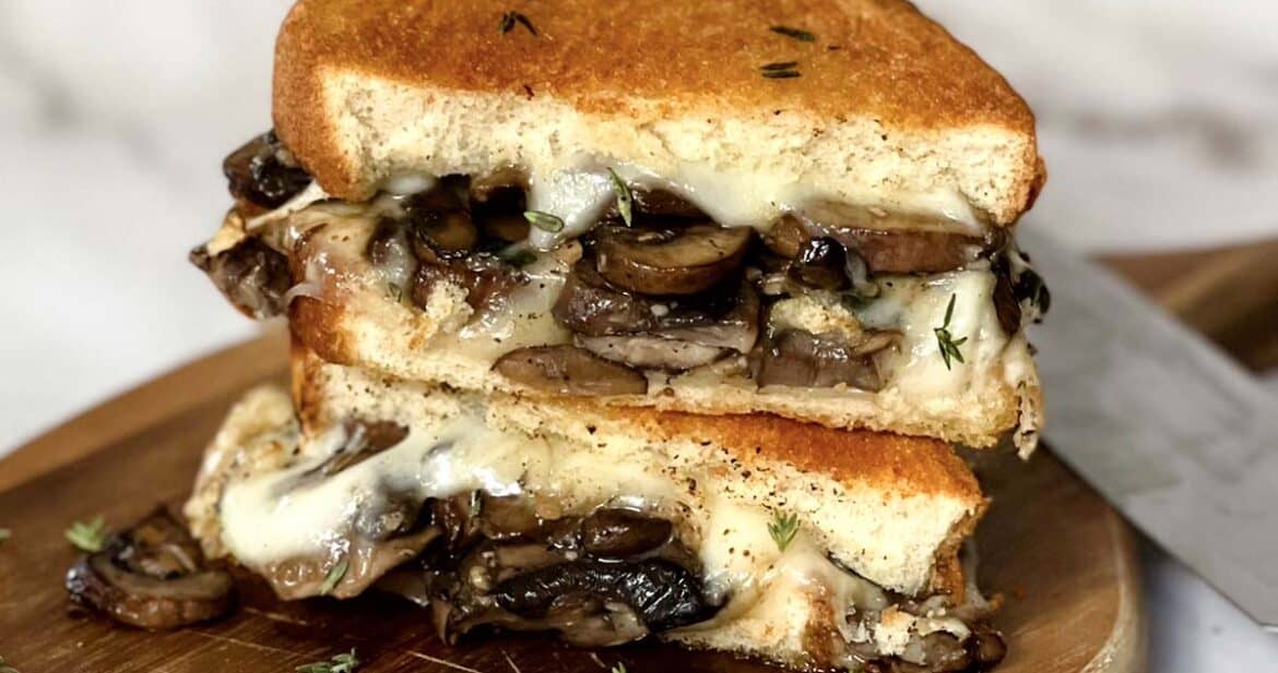 two halves of mushroom grilled cheese stacked on top of each other