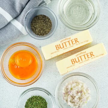 several bowls of measured ingredients next to sticks of butter