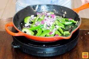 adding peppers and onions to skillet