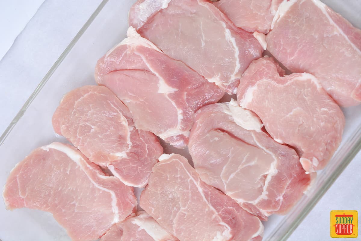 boneless pork chops on a baking sheet