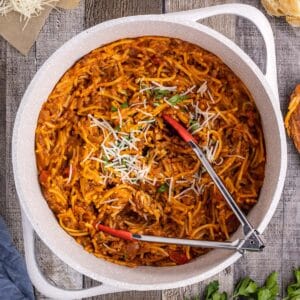 tongs in a bowl of spaghetti