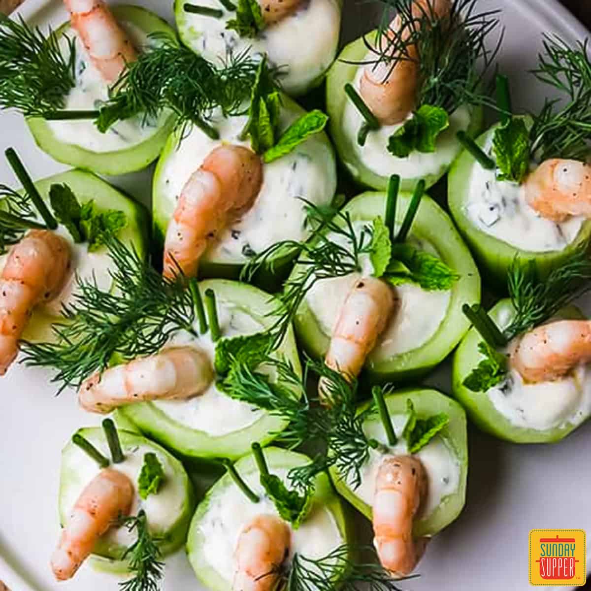 a plate of cucumber and shrimp canapes