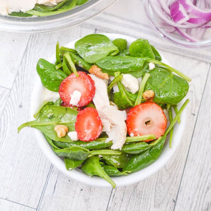 strawberry spinach salad in a white dish