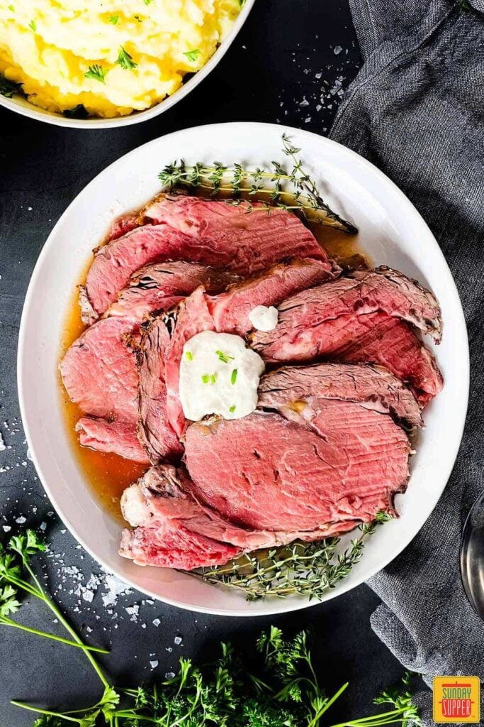 sliced sous vide prime rib arranged on a white plate