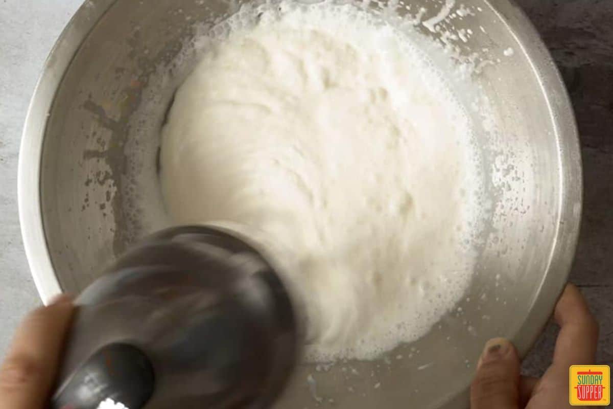 mixing whipped cream with an electric hand mixer