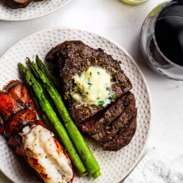 air fryer filet mignon on a plate with asparagus and lobster