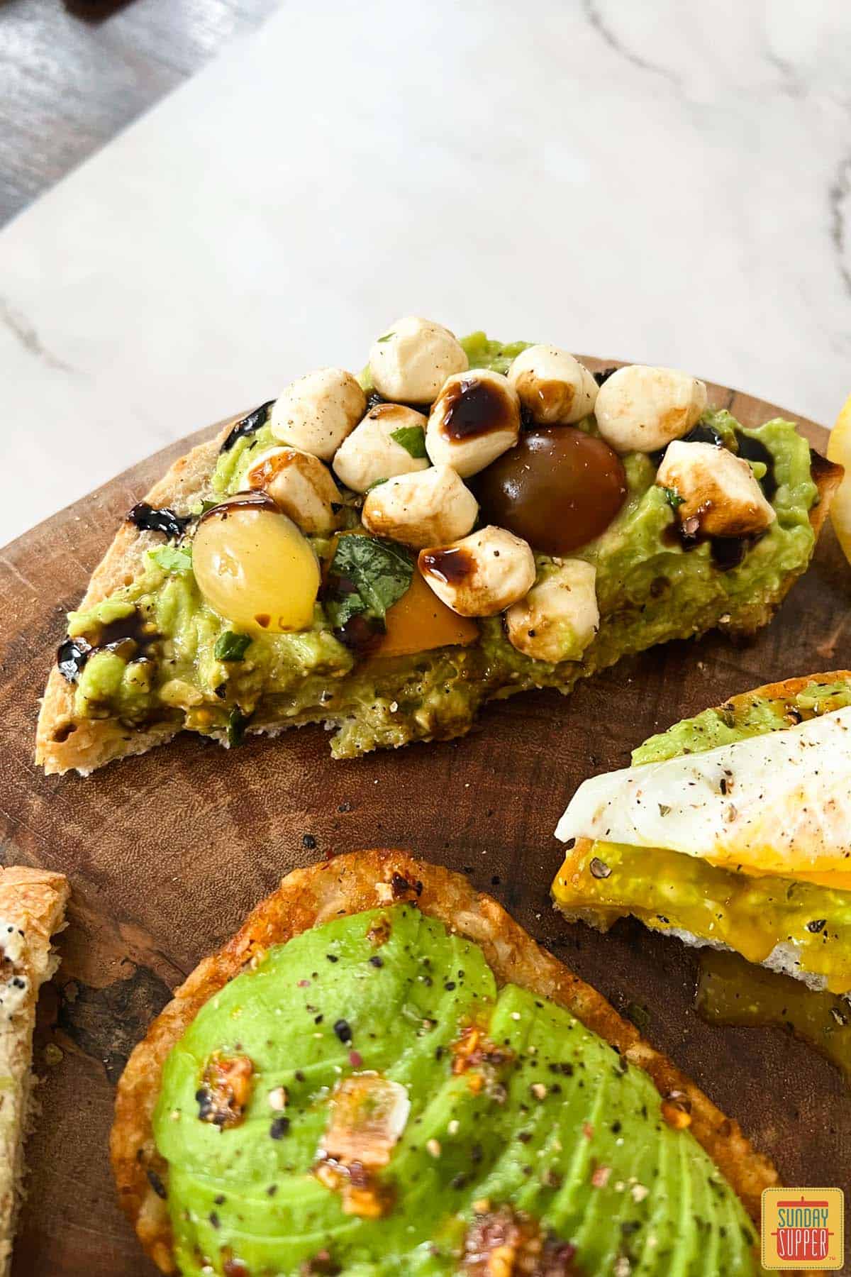 caprese avocado toast on a cutting board