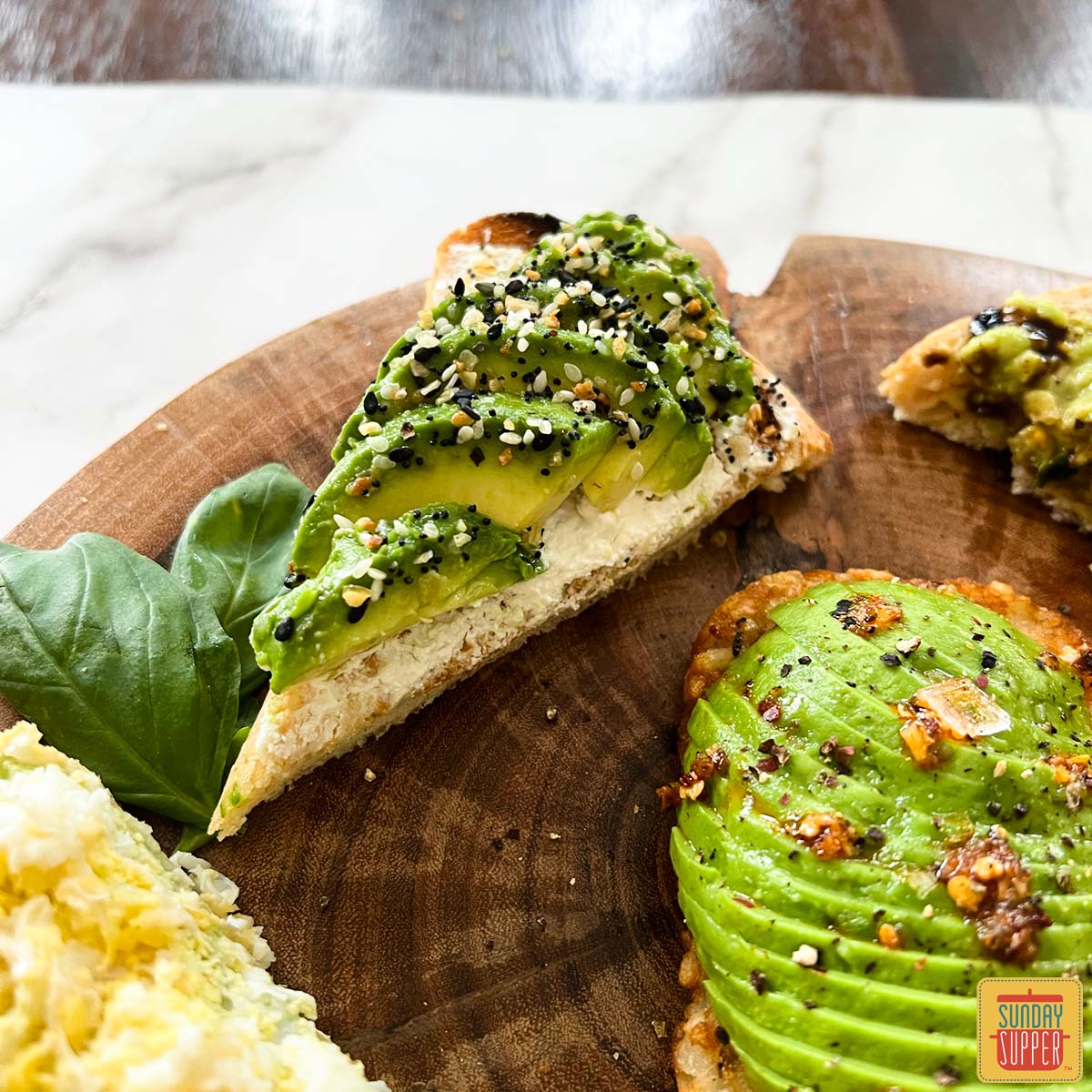 everything bagel avocado toast up close on a wooden board