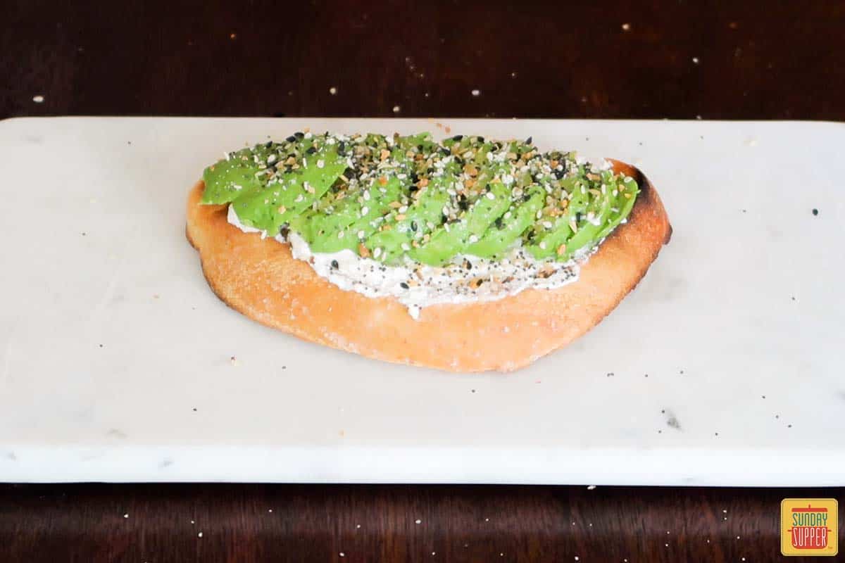 everything bagel seasoning added to avocado toast with cream cheese