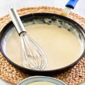 bechamel sauce in a pan with a whisk