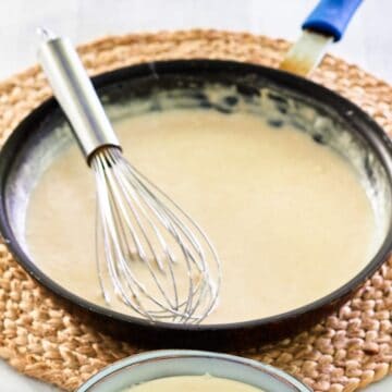 bechamel sauce in a pan with a whisk