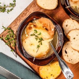 classic french onion soup in a bowl with bread slices