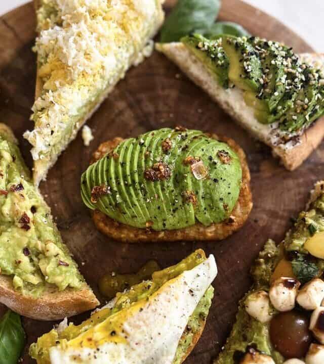 six different kinds of avocado toast on a board