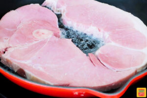 a ham steak in a pan with butter