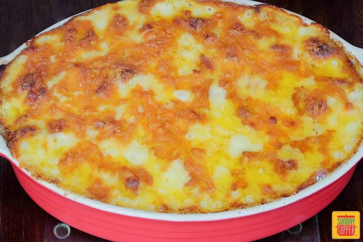 baked ham and potato casserole in a red baking dish