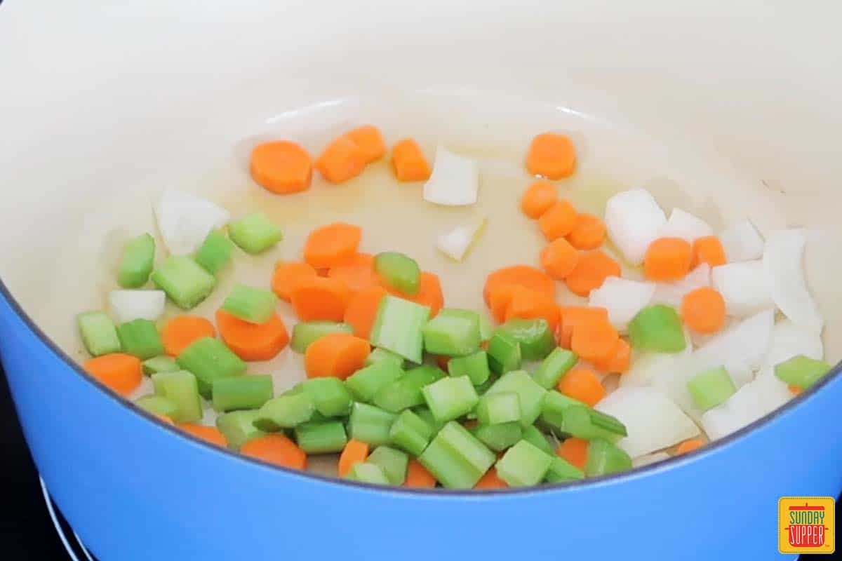 celery carrots and onions added to a pan with oil