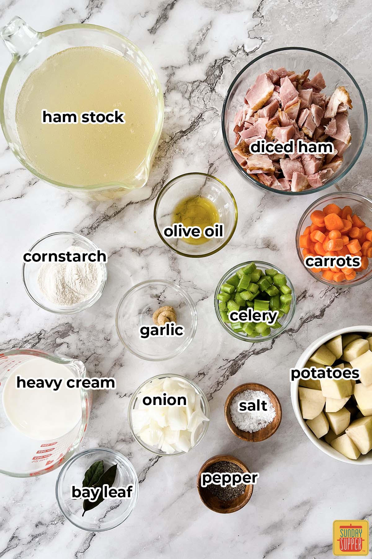 ingredients for ham stock soup on a white surface with labels