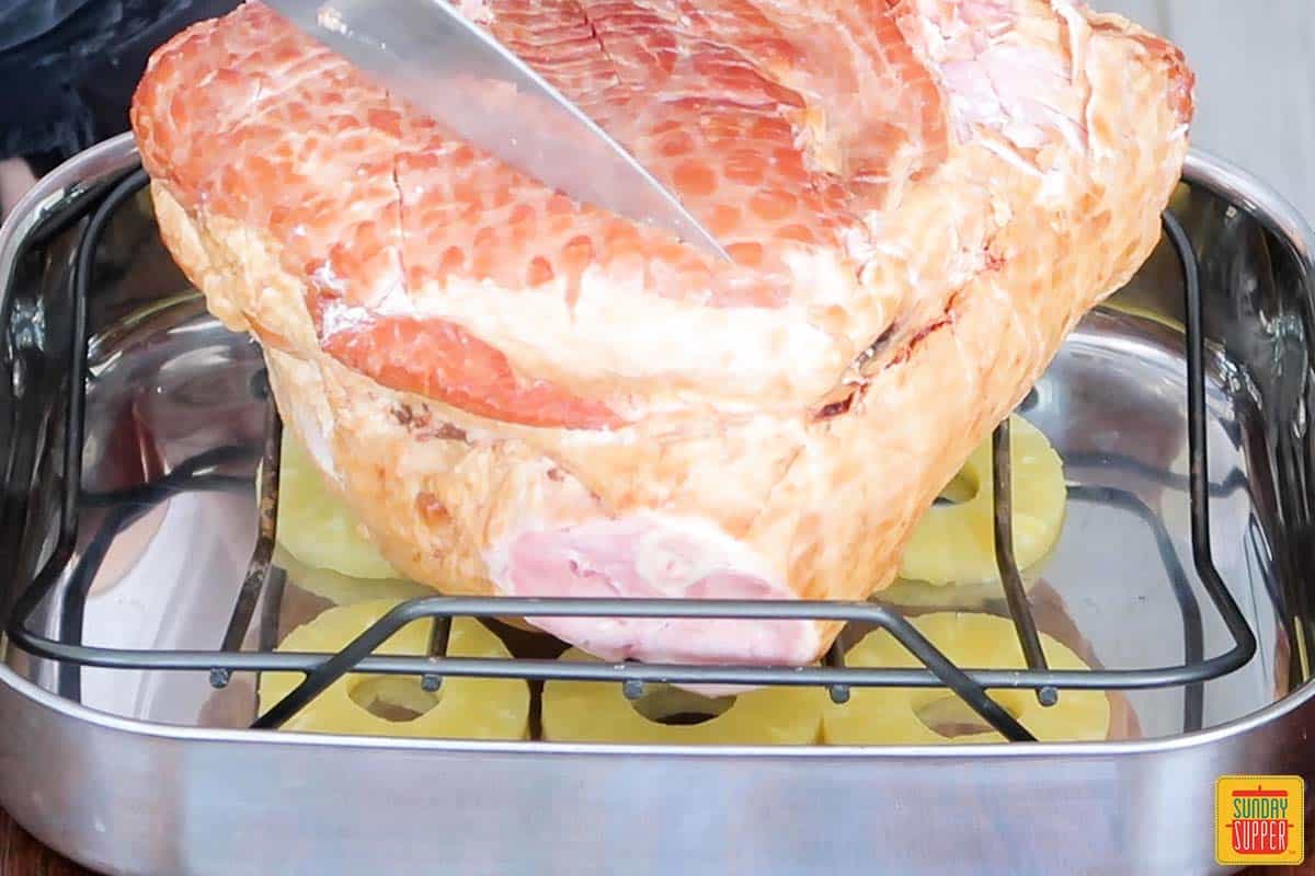 scoring ham on a roasting rack