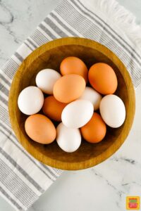 brown and white eggs in a wooden bowl
