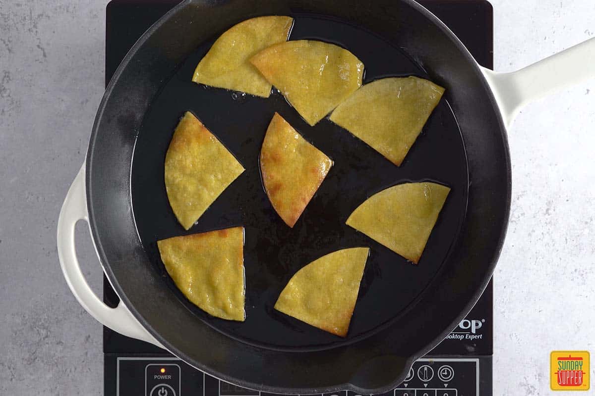 frying tortilla chips in a pan