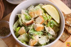 croutons added to a dish of caesar salad